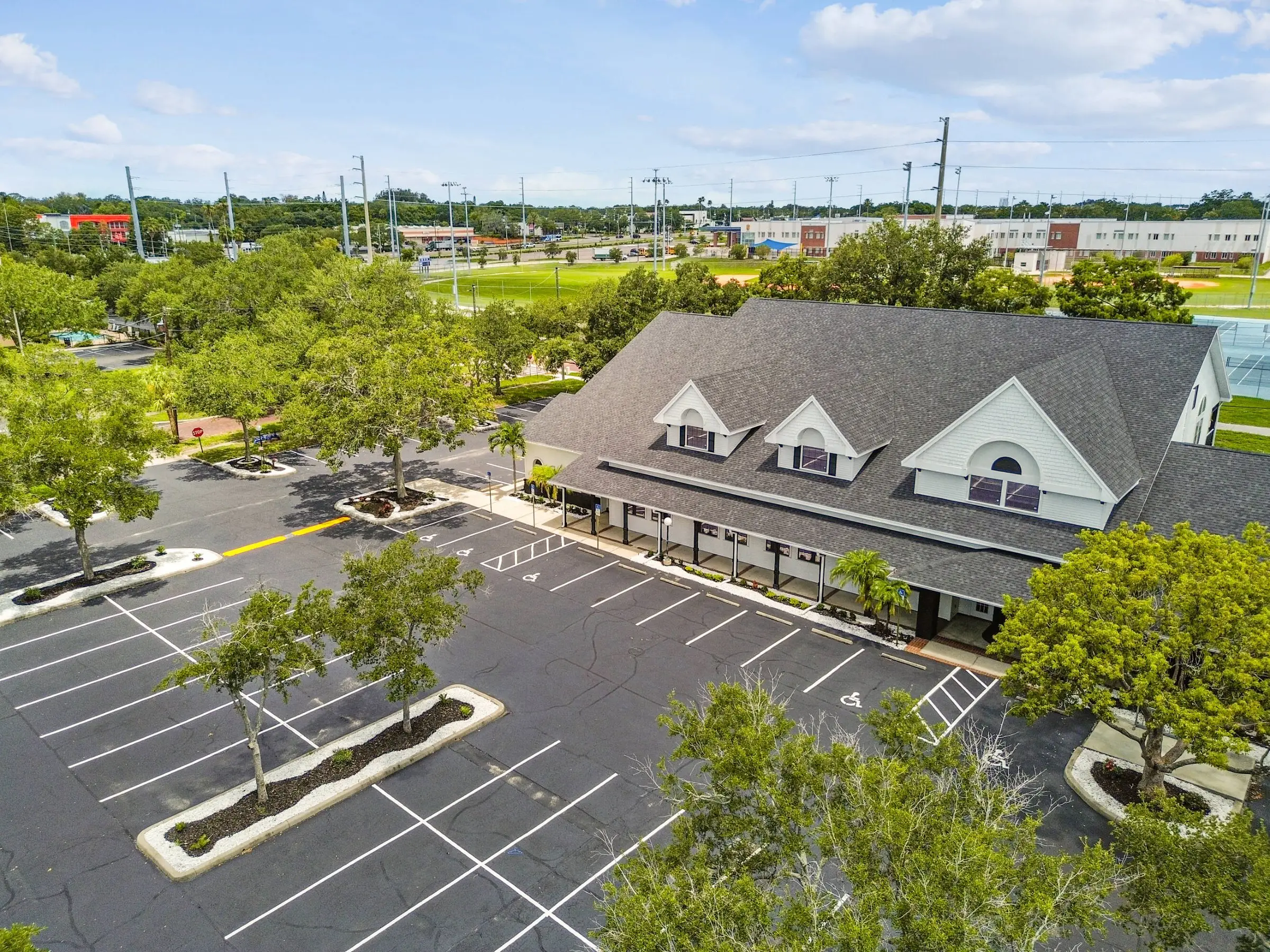 MJ Village from the air: gray-roofed, gabled buildings with Largo High School’s ballfields behind